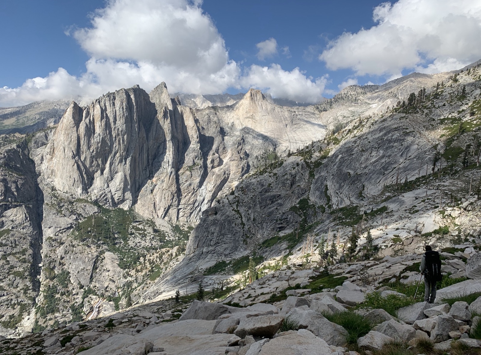 A hiker overlooking granite peaks in the High Sierra